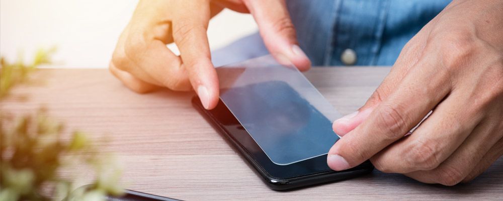 A man putting screen guard or protector on a phone